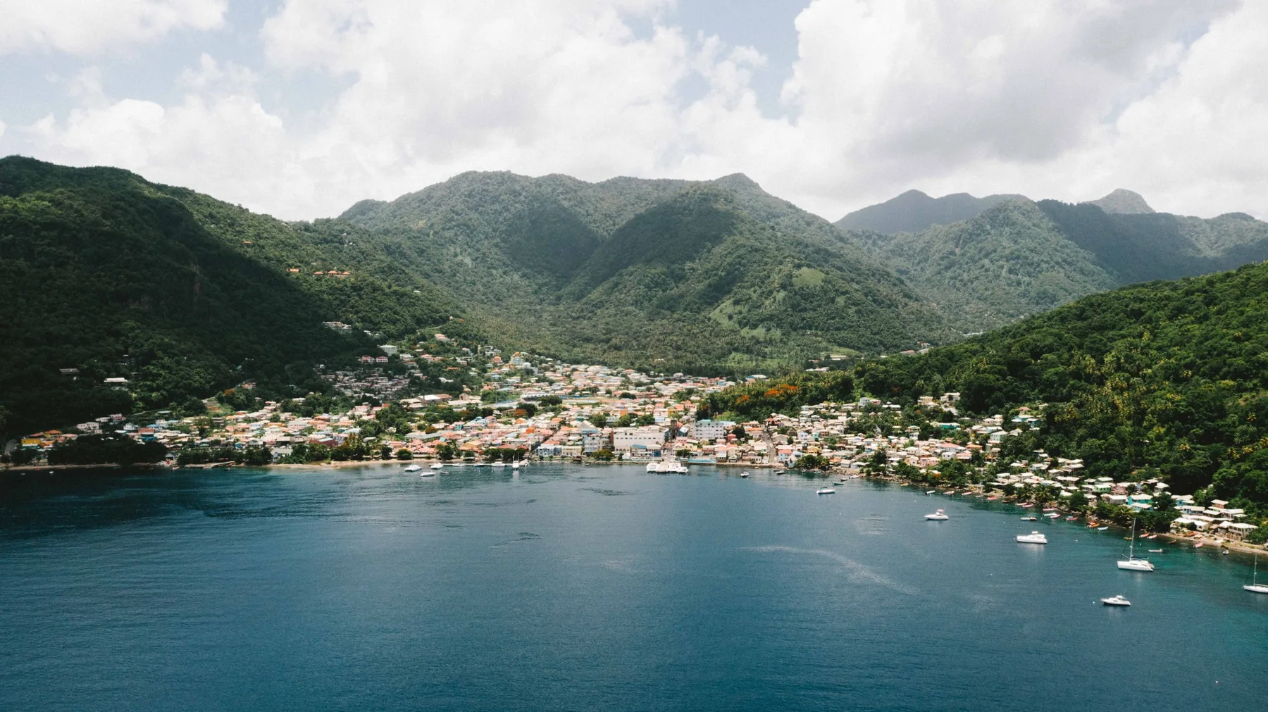 Aerial view of a St. Lucian coastal town surrounded by mountains and sea